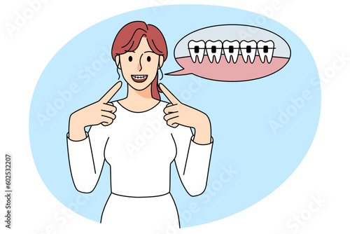 Happy woman point at dental braces on teeth