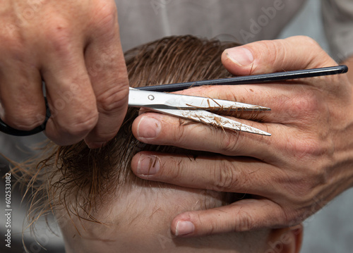 men's haircut with scissors and clipper in the salon