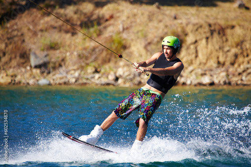Splash, surf and wakeboarding with man in lake for extreme sports, summer break and travel vacation. Wave, adrenaline junkie and fitness with guy skiing on river for health, adventure and speed