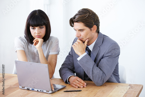 Business people, laptop and thinking in meeting for strategy, planning or brainstorming decision at the office. Thoughtful businessman or woman wondering in team project plan on computer at workplace