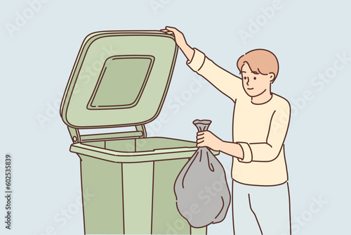 Man throws garbage into large container for concept of overabundance of garbage on planet