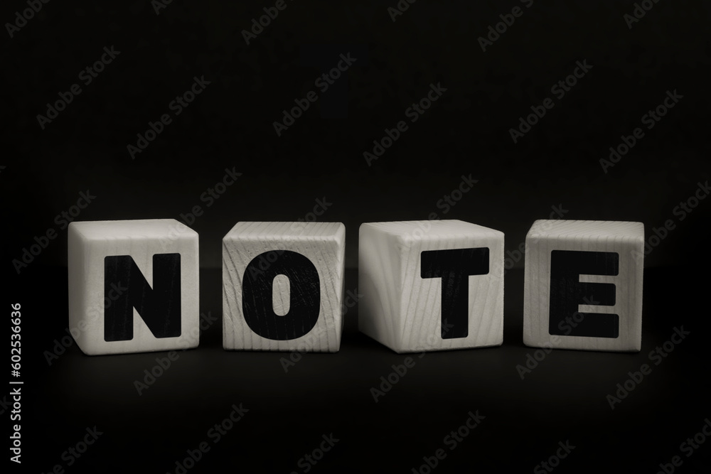 Obraz premium Word NOTE written with wooden cubes. Studio shot of some arranged wooden blocks with a testual message about disinformation.