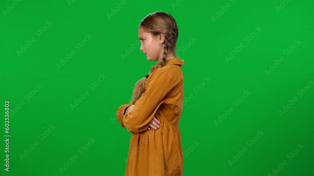Side view portrait of unsatisfied adolescent girl with crossed hands showing tongue out turning away. Dissatisfied Caucasian teenager posing on green screen background Side view portrait of unsatisfied adolescent girl with crossed hands showing tongue out turning away. Dissatisfied Caucasian teenager posing on green screen background