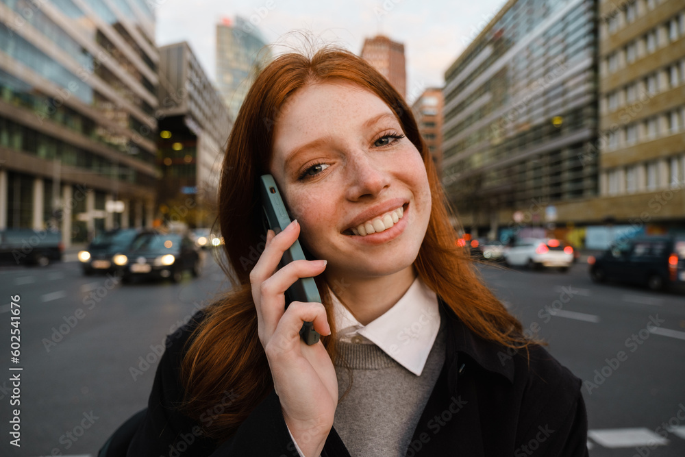 Portrait of smiling woman talking on mobile phone while crossing street Portrait of smiling woman talking on mobile phone while crossing street