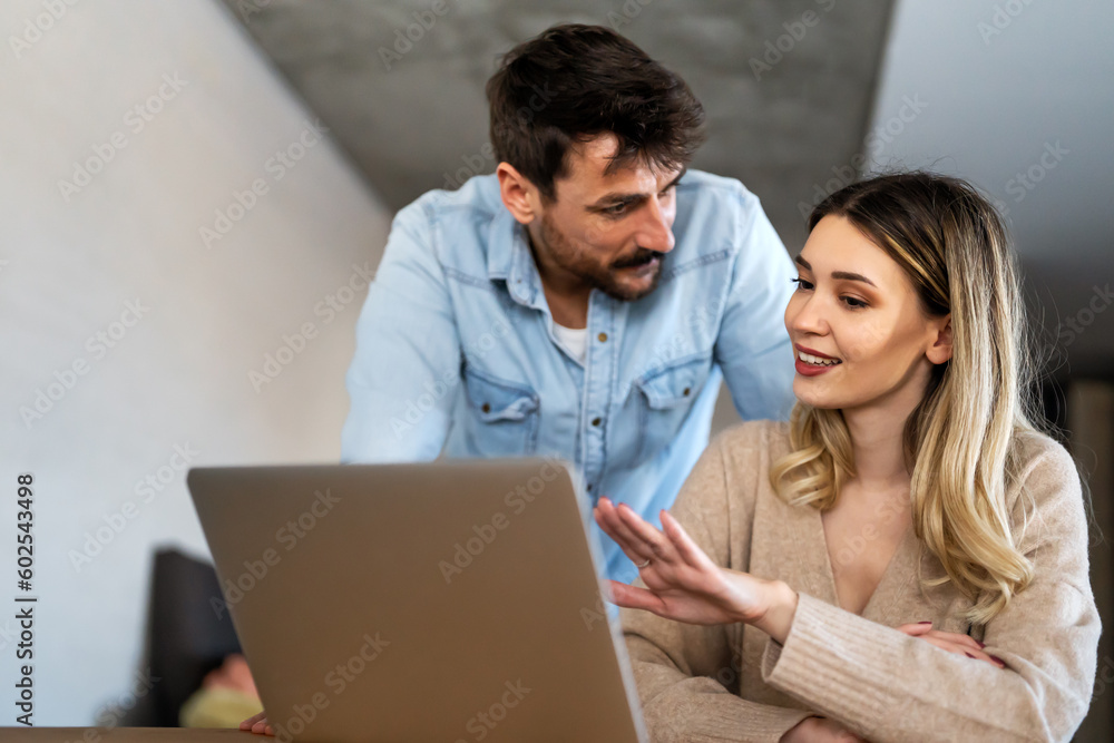Multiethnic colleagues discussing project while working with laptop in office indoors Multiethnic colleagues discussing project while working with laptop in office indoors