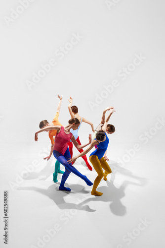 Fototapeta Naklejka Na Ścianę i Meble -  Top view. Creative, talented young girls, ballerinas in colorful bright tights dancing against grey studio background. Concept of beauty, creativity, classic dance style, elegance, contemporary art