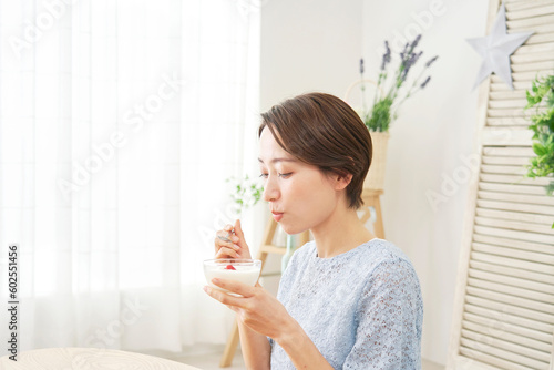 自宅でヨーグルトを食べる女性