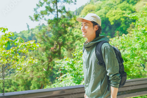 Quadro su tela 美しい新緑の山でハイキングをする若い男性
