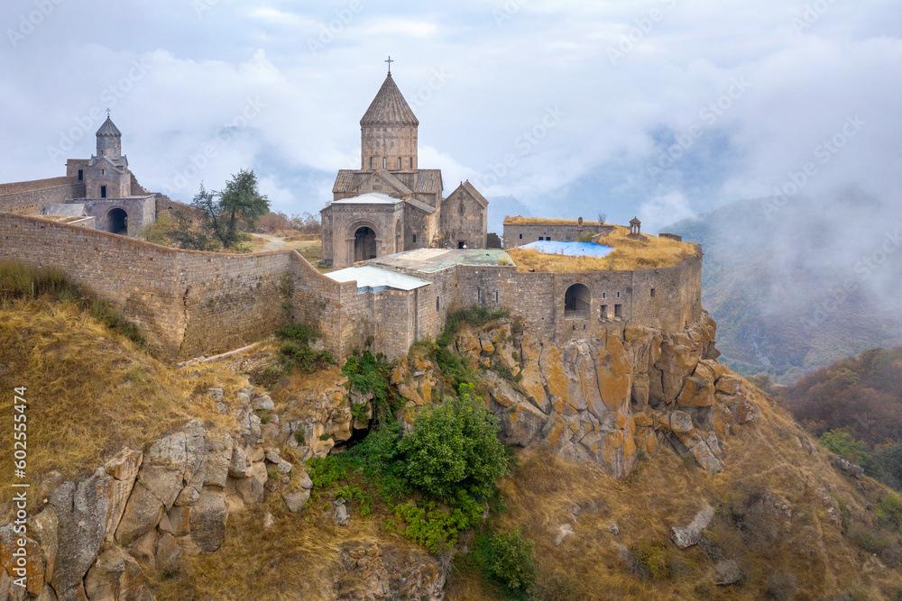 Drone view of Tatev Monastery in autumn morning fog. Tatev, Syunik Province, Armenia.