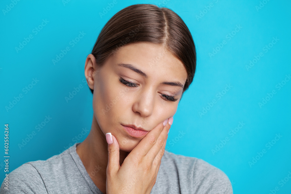 Woman suffering from tooth pain and touching cheek Woman suffering from tooth pain and touching cheek