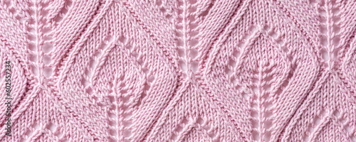 Banner with handmade pink knitting wool texture background with knitted leaf shapes. Top view of knitting clothes