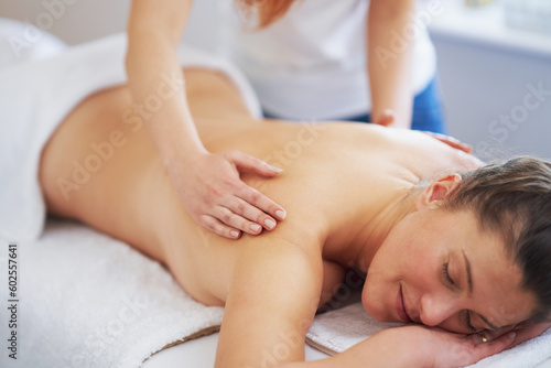 Brunette woman having back massage in salon