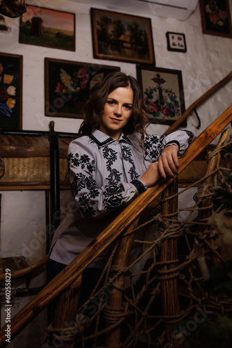 A beautiful young girl in an ethnic vyshyvanka outfit, the shirt is embroidered by hand. Ukrainian brunette with long hair