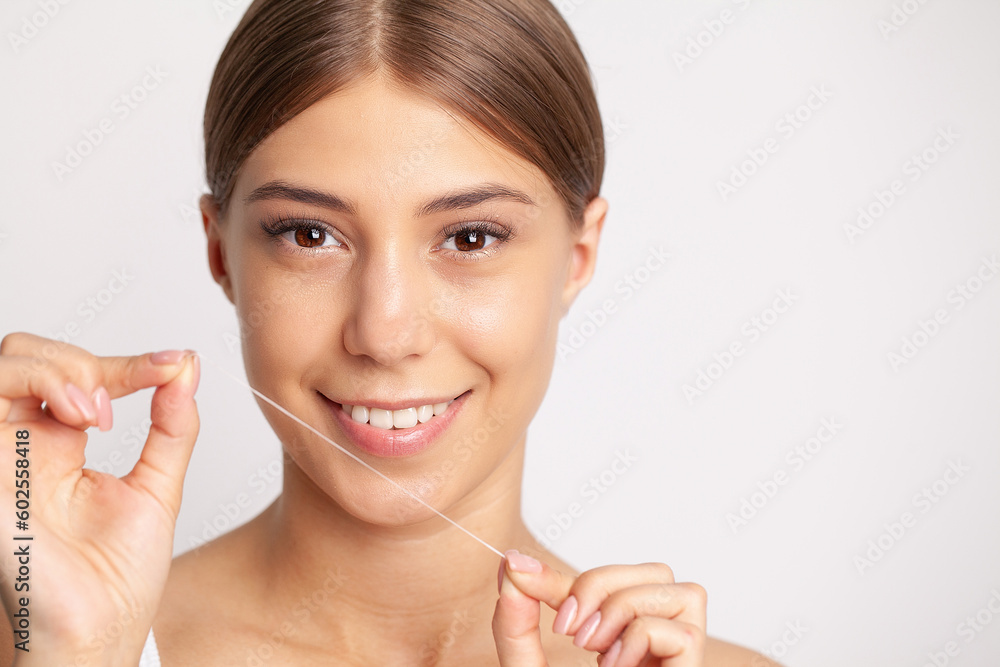 Woman using dental floss for cleaning her teeth Woman using dental floss for cleaning her teeth