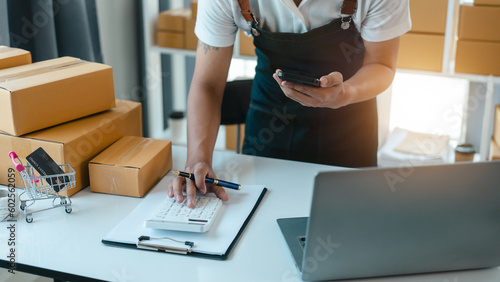 Asian business man seller freelancer prepares box for delivery to  customer in sme supply chain, warehouse.
