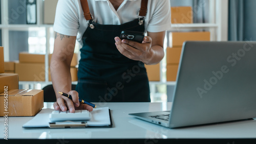 Asian business man seller freelancer prepares box for delivery to  customer in sme supply chain, warehouse.
