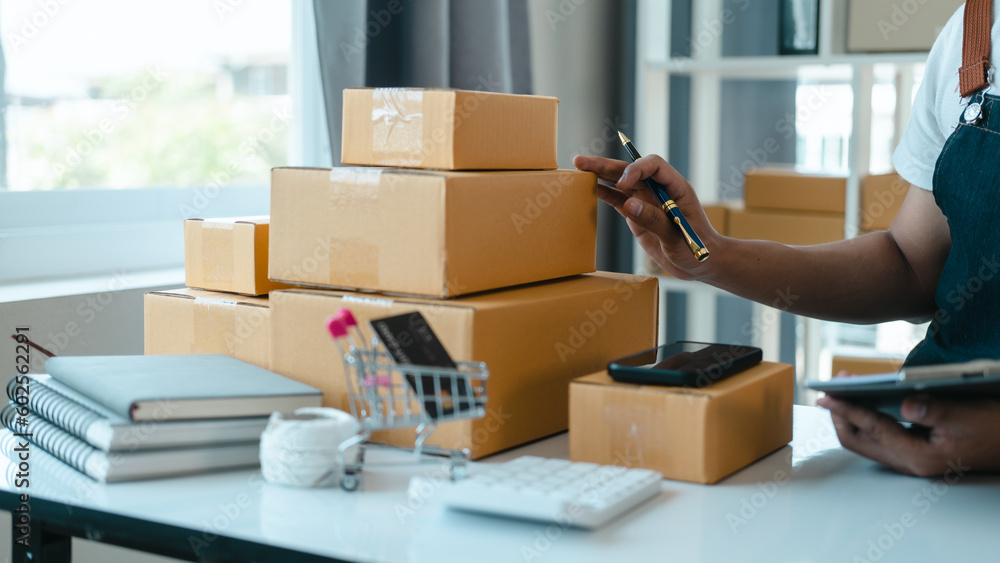 Asian business man seller freelancer prepares box for delivery to customer in sme supply chain, warehouse. Asian business man seller freelancer prepares box for delivery to customer in sme supply chain, warehouse.