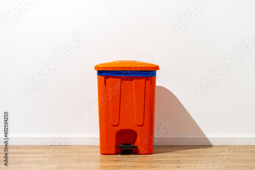 Plastic waste bin with a lid in the room
