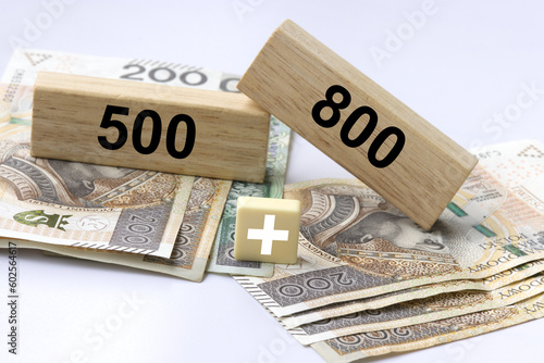 Inscription 800 and 500 plus on wooden blocks with 500 PLN and 800 polish zloty and plus sign. 800 plus is evaluation of the 500 plus program in Poland, state program in the field of social policy. photo