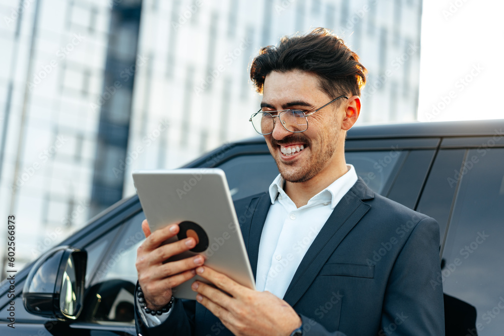 Fototapeta premium Young businessman using digital tablet while standing outdoors