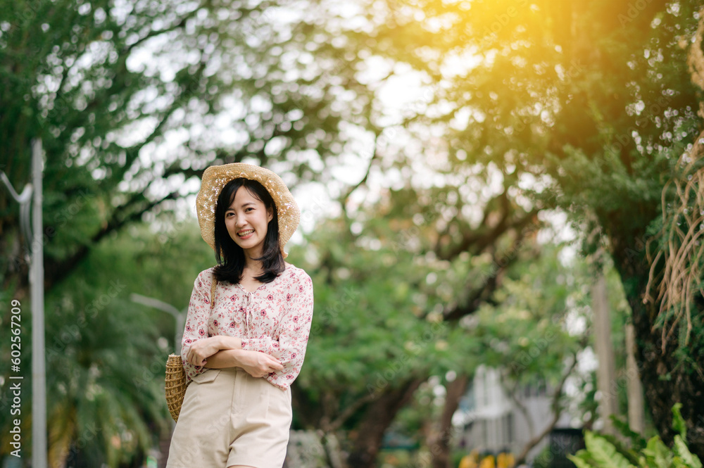 Portrait of asian young woman traveler with weaving hat and basket happy smile on green public park nature background. Journey trip lifestyle, world travel explorer or Asia summer tourism concept. Portrait of asian young woman traveler with weaving hat and basket happy smile on green public park nature background. Journey trip lifestyle, world travel explorer or Asia summer tourism concept.