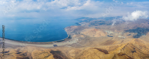 Panoramic aerial view of Sevan lake and Shorzha village from above Mount Artanish on sunny autumn day. Gegharkunik Province, Armenia.