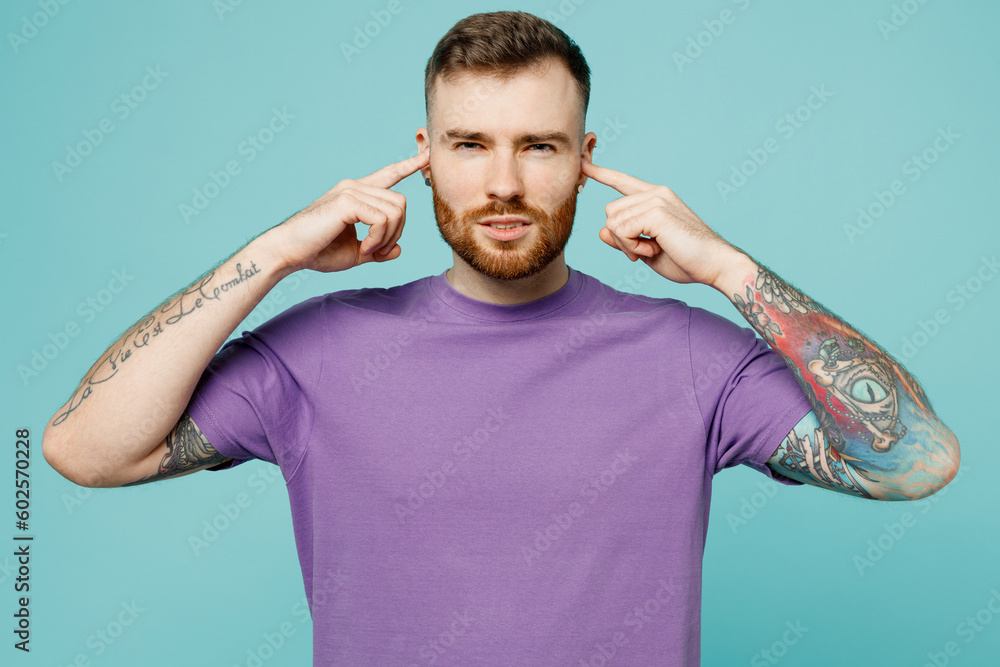 Φωτογραφία Young sad man he wears purple t-shirt cover ears with hands fingers do not want to listen scream isolated on plain pastel light blue cyan background studio portrait