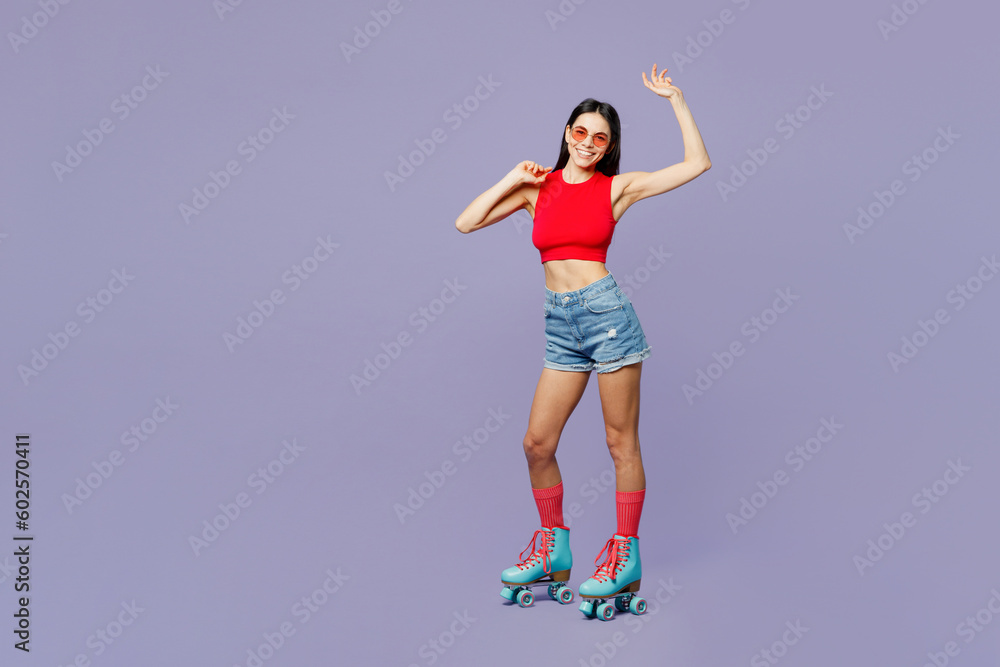 Full body young fun latin woman wears red casual clothes rollers sunglasses rollerblading stand akimbo look camera isolated on plain pastel purple background. Summer sport lifestyle leisure concept. Full body young fun latin woman wears red casual clothes rollers sunglasses rollerblading stand akimbo look camera isolated on plain pastel purple background. Summer sport lifestyle leisure concept.