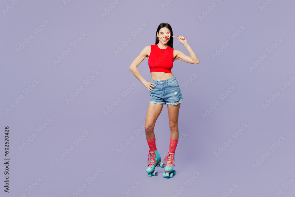 Full body young latin woman wear red casual clothes rollers rollerblading hold cover eye with lollipop look camera isolated on plain pastel purple background. Summer sport lifestyle leisure concept. Full body young latin woman wear red casual clothes rollers rollerblading hold cover eye with lollipop look camera isolated on plain pastel purple background. Summer sport lifestyle leisure concept.