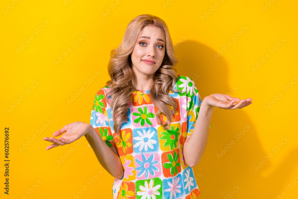 Photo of positive confused nice pretty girl wavy hairdo dressed colorful t-shirt shrugging shoulders isolated on yellow color background Photo of positive confused nice pretty girl wavy hairdo dressed colorful t-shirt shrugging shoulders isolated on yellow color background