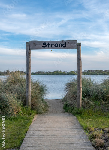 Wooden walkway leading to the lake with blue sky and white clouds Netherlands photo