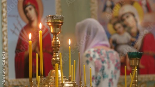 Beautiful Orthodox Church. Icons of the Mother of God on the walls. Candles burn in lamps. A place for prayer to God and believers. Bible and cross in hand.