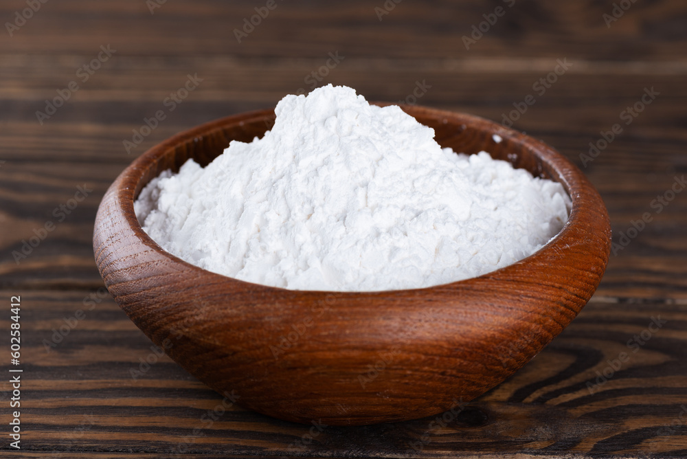 Powdered tapioca starch in a wooden bowl, dry cassava root. Powdered tapioca starch in a wooden bowl, dry cassava root.