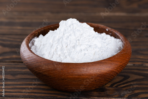 Powdered tapioca starch in a wooden bowl, dry cassava root.