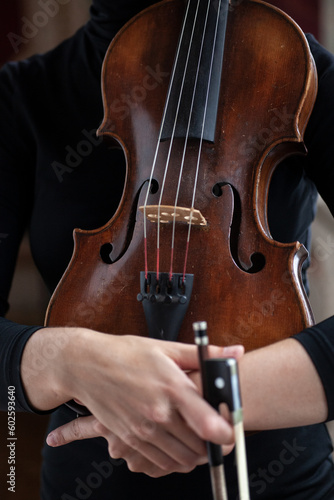 female hands holding viola music instrument, close up photo