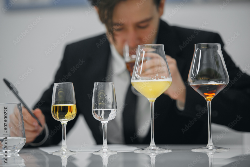 Beginner wine waiter sniffs alcoholic drink during blind tasting. Sommelier school, international certification. Beginner wine waiter sniffs alcoholic drink during blind tasting. Sommelier school, international certification.