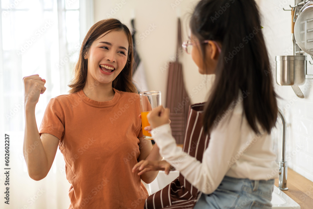Portrait of enjoy happy love asian family mother with little asian girl preparing drinking glass of fresh juice and orange on counter in kitchen at home.Diet concept.healthy drink Portrait of enjoy happy love asian family mother with little asian girl preparing drinking glass of fresh juice and orange on counter in kitchen at home.Diet concept.healthy drink
