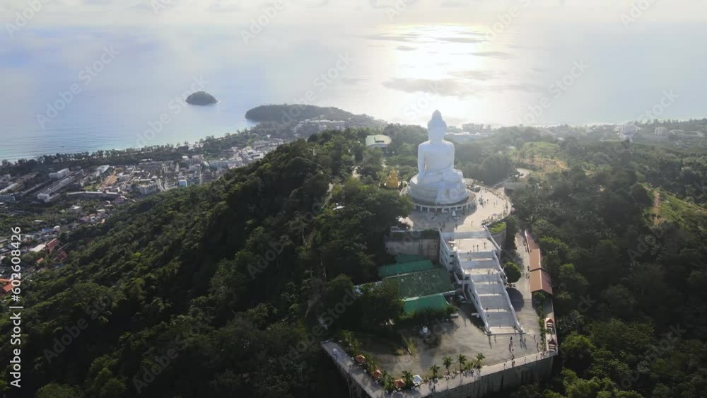 Drone video afternoon light sky and blue ocean are on the back of Phuket Big Buddha statue.white Phuket big Buddha is the one of landmarks on Phuket island Thailand. Drone video afternoon light sky and blue ocean are on the back of Phuket Big Buddha statue.white Phuket big Buddha is the one of landmarks on Phuket island Thailand.
