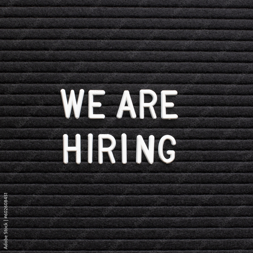 The phrase we are hiring on black letter board The phrase we are hiring on black letter board