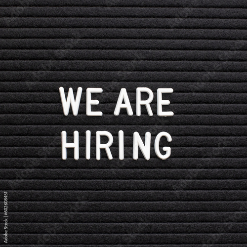 The phrase we are hiring on black letter board