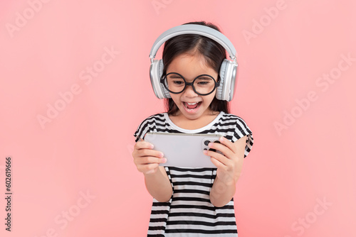 Little girl play phone mobile. Isolated on pink background