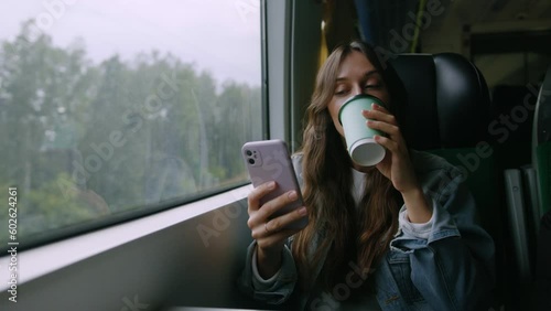 A young attractive woman is texting with a friend using her phone while traveling on a train photo