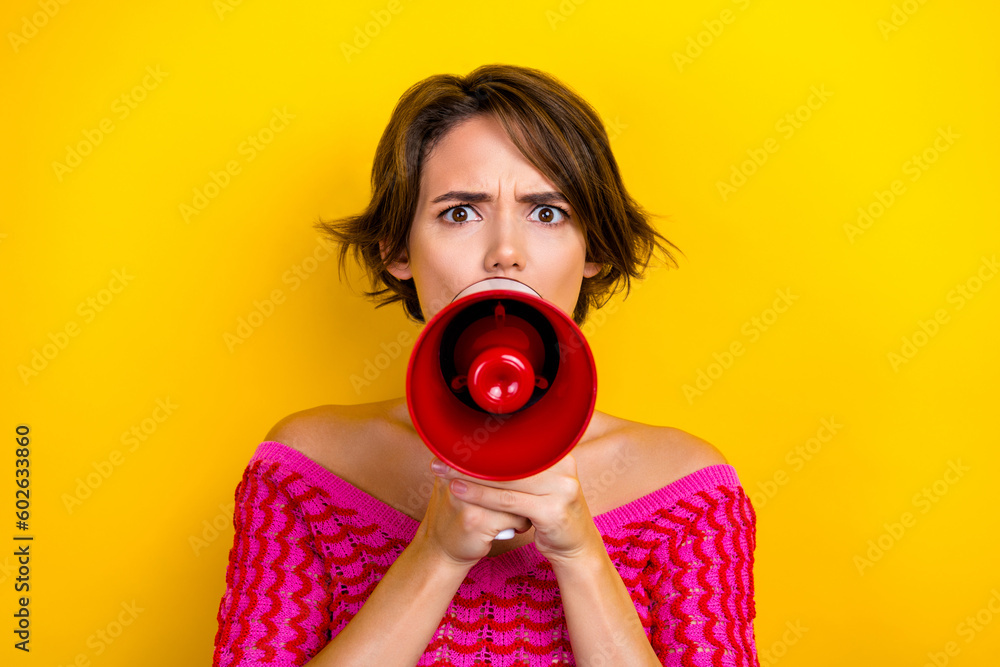 Obraz premium Photo of gloomy serious girl with bob hairstyle dressed off shoulder shirt scream in loudspeaker isolated on yellow color background