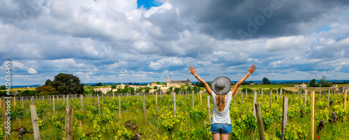 Woman with arms raised in vineyard in France, Bordeaux, Saint Emilion photo