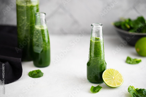 Green smoothie with spinach, banana and lime in small bottles. Raw, vegan, vegetarian, healthy food concept