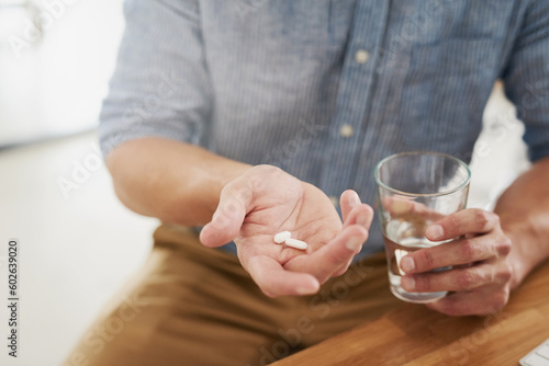 Medicine, pills and water with hands of man for medical, vitamins and supplements. Healthcare, prescription and pharmacy with closeup of male patient at home for drugs, allergy and mental health