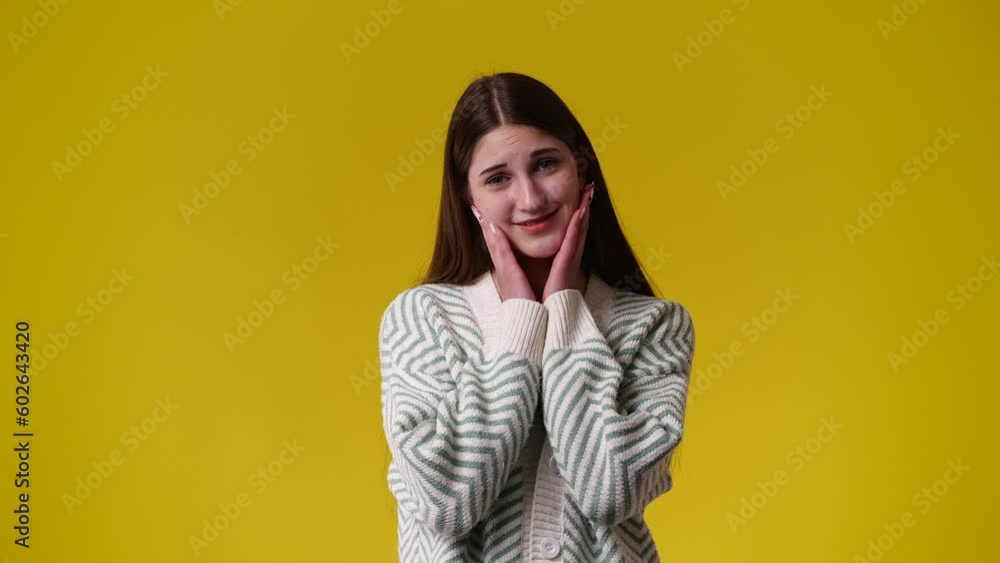 4k video of one girl smiling over yellow backgtround. 4k video of one girl smiling over yellow backgtround.