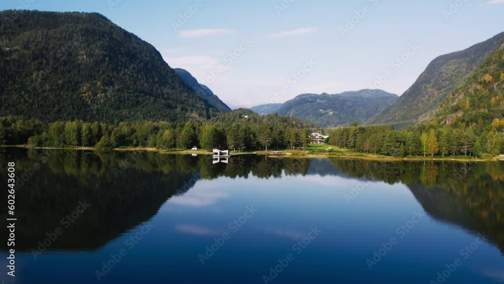 Beautiful idyllic aerial shot of scandinavian minimalistic design hut or sauna on edge of pristine lake or fjord. Amazing scandinavian vacation concept in Norway Beautiful idyllic aerial shot of scandinavian minimalistic design hut or sauna on edge of pristine lake or fjord. Amazing scandinavian vacation concept in Norway