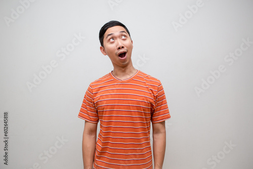 Asian man orange shirt amazed face looking up isolated