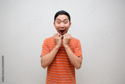 Asian man orange shirt feels excited shocked face isolated